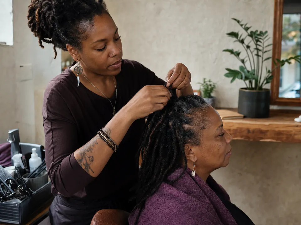 Loctician retwisting a client's locs