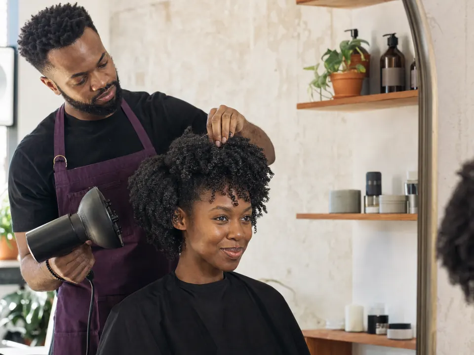 Natural-hair stylist defining a client's coils